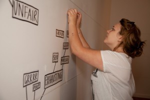 Kate Symmans adds words to the Ramp Gallery wall.