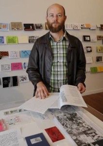 Co-curator of the Zinefest Bryce Galloway with some of the zines that will be on display. Photo: supplied