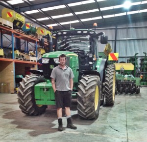 Chris Haveman, training coordinator at GAVINS Ltd, with one of the company’s John Deere tractors similar to those used in the competition. Photo: Anna Clausen
